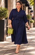 Vestido camisero largo con lazo de Boutiquemirel, diseño curvy, tela ligera y cinturón en la cintura, modelo en color neutro.