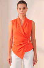 Blusa asimétrica con broche dorado
