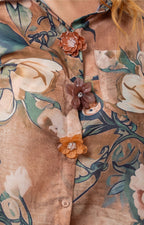 Conjunto floral con blusa camisera de boutiquemirel, botones en la parte frontal y diseño estampado colorido.