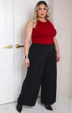 Pantalón asimétrico negro de estilo curvy con aplicaciones, de la marca Boutiquemirel, mostrando detalles de diseño en la imagen.