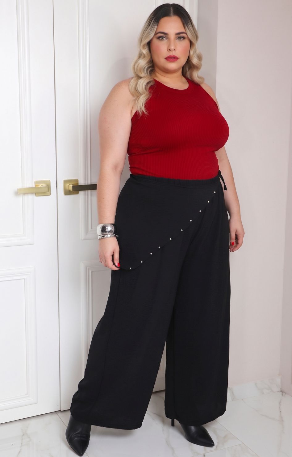 Pantalón asimétrico negro de estilo curvy con aplicaciones, de la marca Boutiquemirel, mostrando detalles de diseño en la imagen.