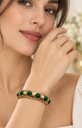 Brazalete rígido dorado con piedras verdes