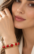 Brazalete rígido dorado con piedras rojas